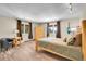 Cozy bedroom with two windows, a wooden bed frame, hardwood floors, and unique light fixtures at 27100 Molly Dr, Conifer, CO 80433