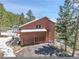 Spacious home with an attached two-car garage surrounded by mature trees at 27100 Molly Dr, Conifer, CO 80433