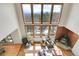 Bright living room featuring large windows with scenic views, wood floors, and a cozy fireplace at 27100 Molly Dr, Conifer, CO 80433