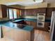 This kitchen features ample wood cabinetry, stainless steel appliances, and a breakfast bar cooktop at 2879 Gold Creek Dr, Elizabeth, CO 80107