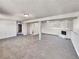 Open basement featuring neutral carpet, support beams, and a fireplace at 6189 Pontiac St, Commerce City, CO 80022