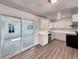 Well-lit kitchen with white cabinets, stainless steel appliances, and a sliding glass door at 6189 Pontiac St, Commerce City, CO 80022