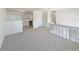 Upstairs living room featuring carpet and a glimpse into the modern kitchen at 6189 Pontiac St, Commerce City, CO 80022