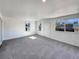 Bright living room area with neutral carpet and multiple windows letting in natural light at 6189 Pontiac St, Commerce City, CO 80022