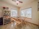 Bright dining area features a wooden table with bench seating, a ceiling fan, and natural light from large windows at 319 Mountain View Ave, Fort Lupton, CO 80621