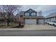 Charming home featuring a two-car garage, brick facade, and manicured front yard landscaping at 319 Mountain View Ave, Fort Lupton, CO 80621
