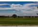 Scenic golf course community view with blue skies and the Rocky Mountains in the background at 319 Mountain View Ave, Fort Lupton, CO 80621