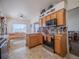 Well-appointed kitchen with wood cabinets, stainless steel appliances, and eat-in dining space at 319 Mountain View Ave, Fort Lupton, CO 80621
