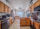 Well-lit kitchen featuring stainless steel appliances, wood cabinets, and sight lines to a sunny dining area at 319 Mountain View Ave, Fort Lupton, CO 80621