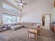 Bright living room with a sectional couch, large windows, and vaulted ceilings at 319 Mountain View Ave, Fort Lupton, CO 80621