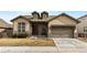 Tan two-story house with a brown door and attached garage at 14240 Ivanhoe St, Thornton, CO 80602