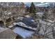 An aerial view of a quaint home with a dark roof, nestled in a tree-filled suburban neighborhood at 3318 S Dayton Ct, Denver, CO 80231