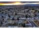 Expansive aerial view of neighborhood homes and city skyline at sunset; mountains in the background at 3318 S Dayton Ct, Denver, CO 80231
