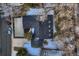 Aerial view of a home with a driveway, landscaping, and a dark roof in a wintry setting at 3318 S Dayton Ct, Denver, CO 80231
