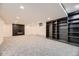 Spacious carpeted basement featuring a cozy fireplace and custom built-in shelving for storage at 3318 S Dayton Ct, Denver, CO 80231