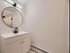 Modern bathroom features a sleek vanity with a stylish round mirror and contemporary fixtures at 3318 S Dayton Ct, Denver, CO 80231
