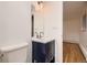 Contemporary bathroom featuring a blue vanity with mirror and modern fixtures at 3318 S Dayton Ct, Denver, CO 80231