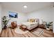 Cozy bedroom featuring hardwood floors, soft lighting, and comfortable furnishings at 3318 S Dayton Ct, Denver, CO 80231