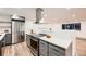 Updated kitchen showcasing stainless steel appliances, a breakfast bar, and modern lighting at 3318 S Dayton Ct, Denver, CO 80231