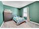 Charming bedroom with large window, dark wood dresser, and plush carpet at 2791 Quarterland St, Strasburg, CO 80136