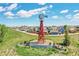 Scenic community entrance featuring a decorative windmill and well-maintained landscaping at 2791 Quarterland St, Strasburg, CO 80136