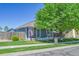 Quaint home featuring a cozy front porch, American flag, and a well-manicured lawn at 2791 Quarterland St, Strasburg, CO 80136
