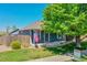 Inviting home exterior showcasing a welcoming porch, American flag, and beautiful landscaping at 2791 Quarterland St, Strasburg, CO 80136