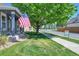 View of front yard with grass, large tree and an American flag at 2791 Quarterland St, Strasburg, CO 80136