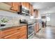 Bright kitchen featuring wood cabinets, stainless steel appliances and modern backsplash at 2791 Quarterland St, Strasburg, CO 80136