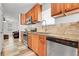 A modern kitchen boasts wood cabinetry and stainless steel appliances, enhancing the space at 2791 Quarterland St, Strasburg, CO 80136