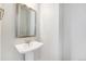 Small powder room featuring white pedestal sink and silver mirror at 11873 W 51St Ave, Wheat Ridge, CO 80033
