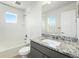 Bathroom with granite countertop, white subway tile, window, toilet, and shower at 11873 W 51St Ave, Wheat Ridge, CO 80033
