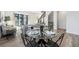 Modern dining room with round glass table, stylish chairs, and an open view of the living area at 11873 W 51St Ave, Wheat Ridge, CO 80033