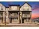 Modern townhome exterior showcasing stone accents, dual balconies, and contemporary design elements at 11873 W 51St Ave, Wheat Ridge, CO 80033