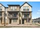Modern townhome exterior showcasing stone accents, dual balconies, and contemporary design elements at 11873 W 51St Ave, Wheat Ridge, CO 80033