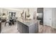 Modern kitchen with large island, stainless steel appliances, and open layout to the dining area at 11873 W 51St Ave, Wheat Ridge, CO 80033