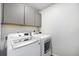 Laundry room features new white front-load washer and dryer and gray cabinets at 11873 W 51St Ave, Wheat Ridge, CO 80033