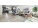 Open-concept living area with modern furniture, light hardwood floors, and kitchen in the background at 11873 W 51St Ave, Wheat Ridge, CO 80033