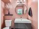 Stylish pink bathroom with a round mirror, modern vanity, and a unique decorative touch at 1390 N Emerson St # 407, Denver, CO 80218