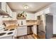Well-lit kitchen with white cabinets, stainless steel appliances, butcher block countertops, and a patterned rug at 1390 N Emerson St # 407, Denver, CO 80218