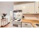 Functional kitchen featuring white cabinets, light countertops, and a view into the next room at 1390 N Emerson St # 407, Denver, CO 80218