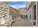Private patio area features stone walls, a trellis, and outdoor seating with a sliding door to the interior at 1390 N Emerson St # 407, Denver, CO 80218