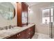 Bathroom features a vanity with granite counters, sink, and a large round mirror at 1023 S High St, Denver, CO 80209