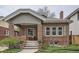 Charming brick home featuring a covered front porch with seating area at 1023 S High St, Denver, CO 80209