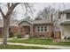 Beautiful brick home featuring a well-maintained lawn and a charming covered porch at 1023 S High St, Denver, CO 80209