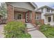 Inviting brick home with a cozy covered porch and manicured green lawn at 1023 S High St, Denver, CO 80209