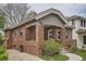 Classic brick home featuring a quaint covered front porch and manicured landscaping at 1023 S High St, Denver, CO 80209