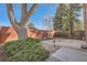 Backyard patio area with mature trees, brick privacy wall, and landscaped garden at 2201 S Holly St # 1, Denver, CO 80222