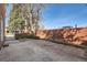 Brick-walled backyard features a concrete patio area with mature landscaping and sunny exposure at 2201 S Holly St # 1, Denver, CO 80222