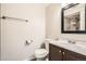 Modern bathroom featuring a dark vanity, toilet, and a mirror reflecting the tiled shower at 2201 S Holly St # 1, Denver, CO 80222
